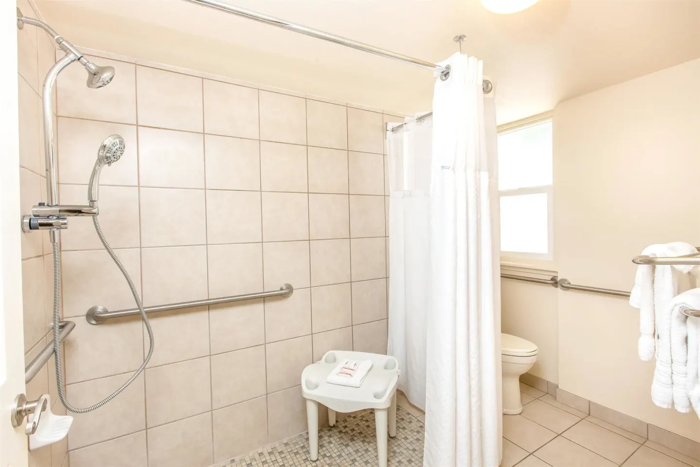 Accessible bathroom with roll-in shower and grab bars at Days Inn Maui Oceanfront.