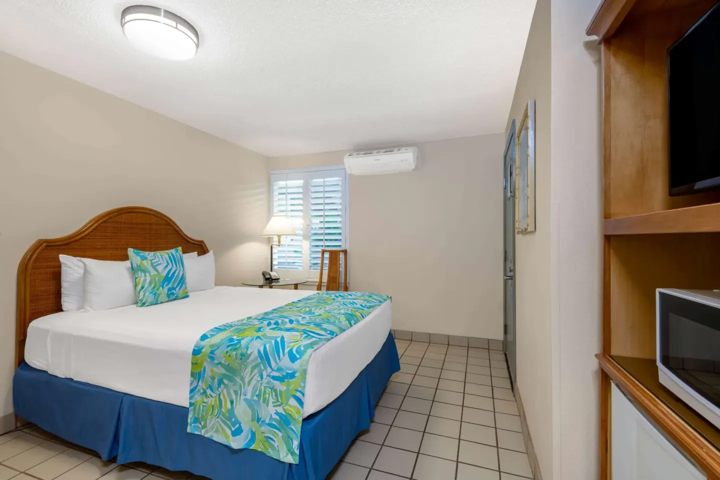 Accessible guest room with queen bed and tiled floor at Days Inn Maui Oceanfront.