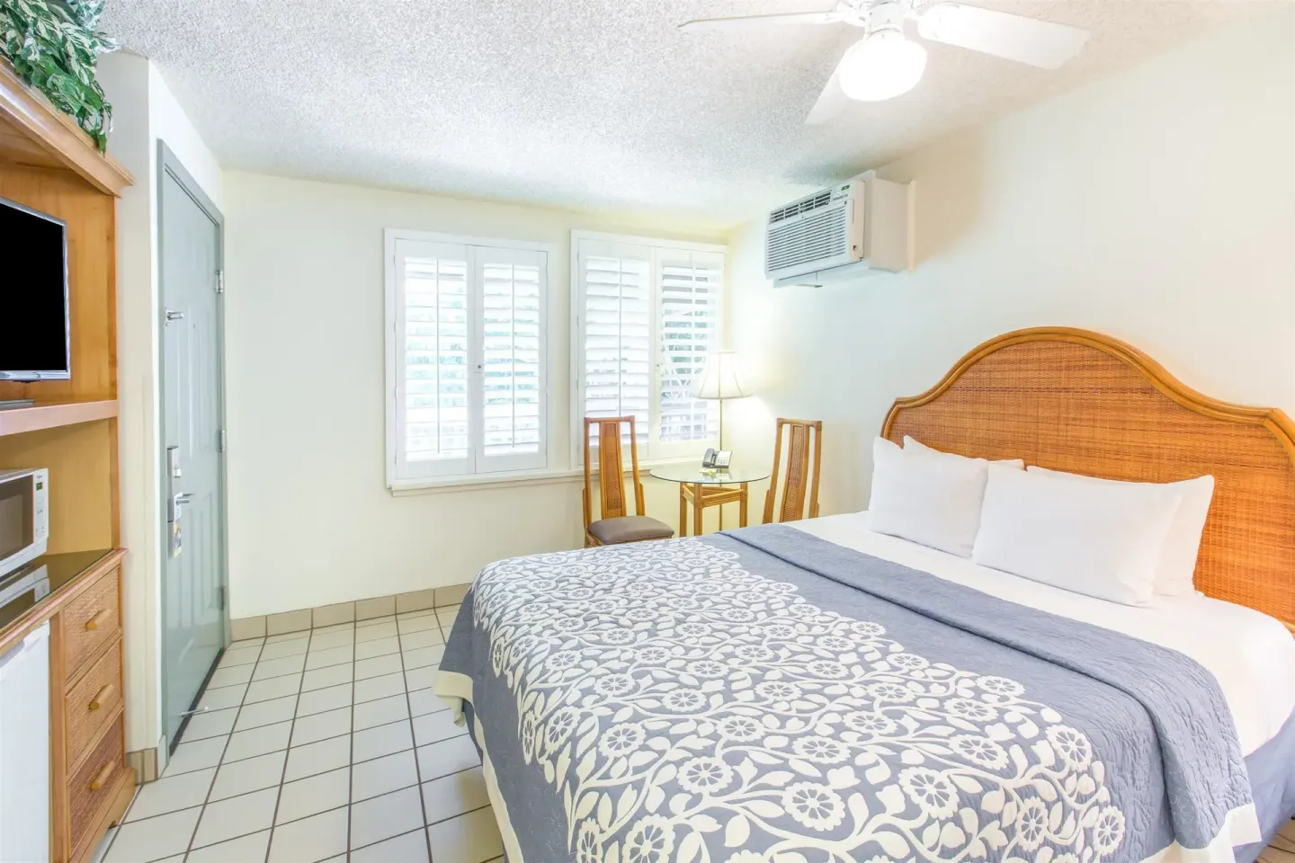 Standard Room with one bed, shutters, and media cabinet at Days Inn Maui Oceanfront.