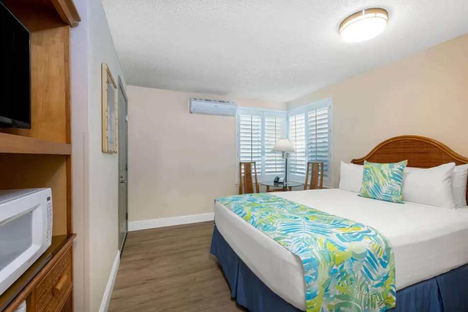 Standard Room with one bed, tropical runner, and wood-look floor at Days Inn Maui Oceanfront.