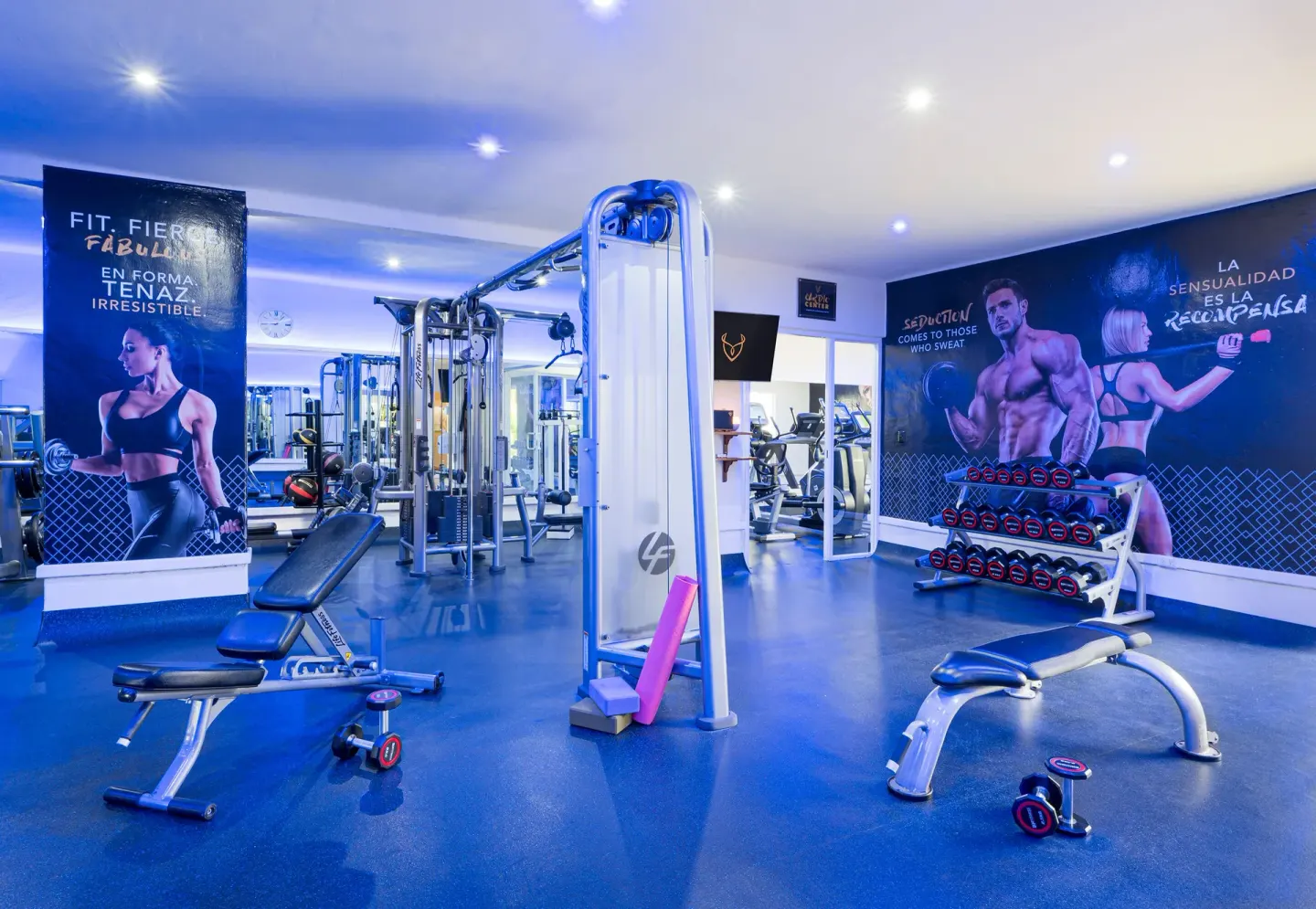 Fitness center with weight benches and cable machines at Desire Pearl Riviera Maya Resort.
