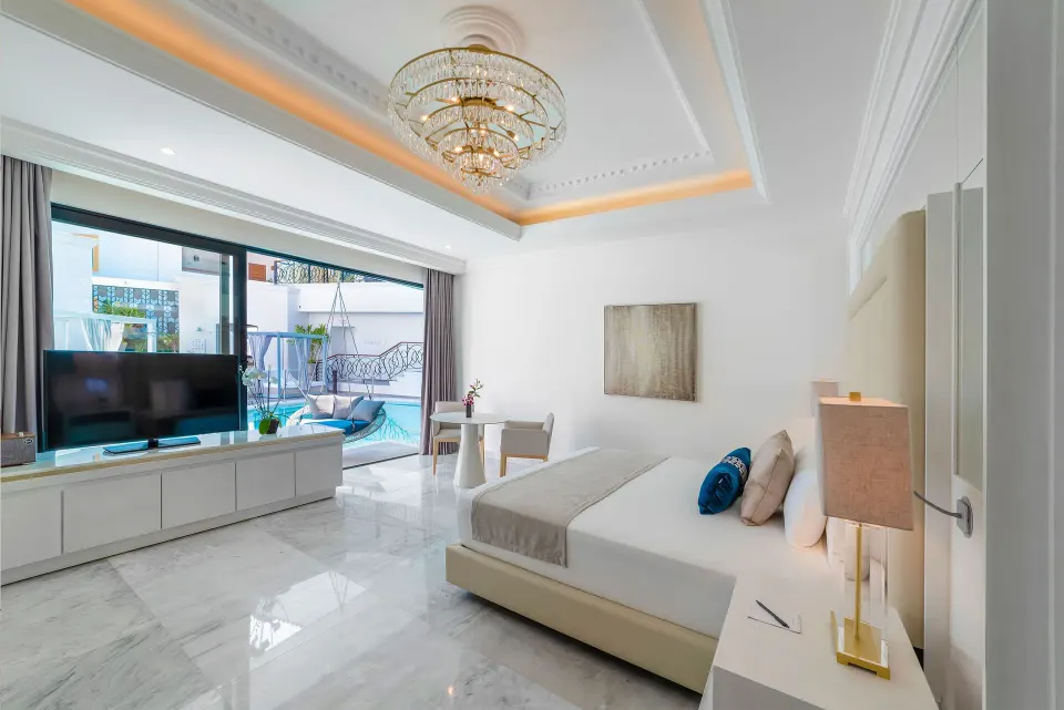 Bright king bed guest room with terrace pool view at Desire Pearl Riviera Maya Resort.