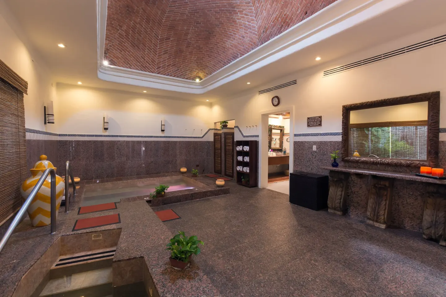 Spa hydrotherapy room with tiled pools and brick vaulted ceiling at Desire Pearl Riviera Maya Resort.