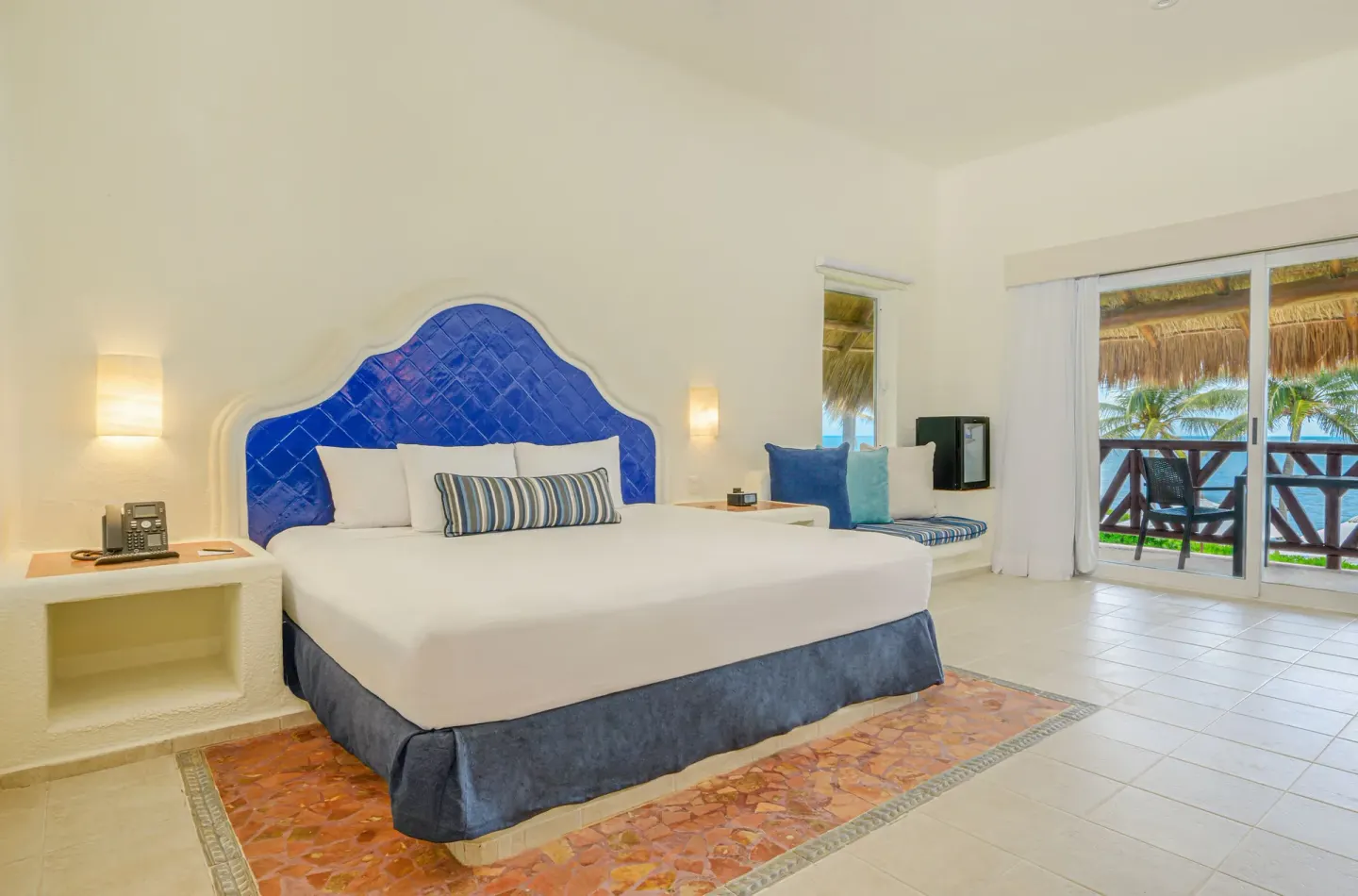 Junior Suite king bed and balcony at Desire Pearl Riviera Maya Resort.