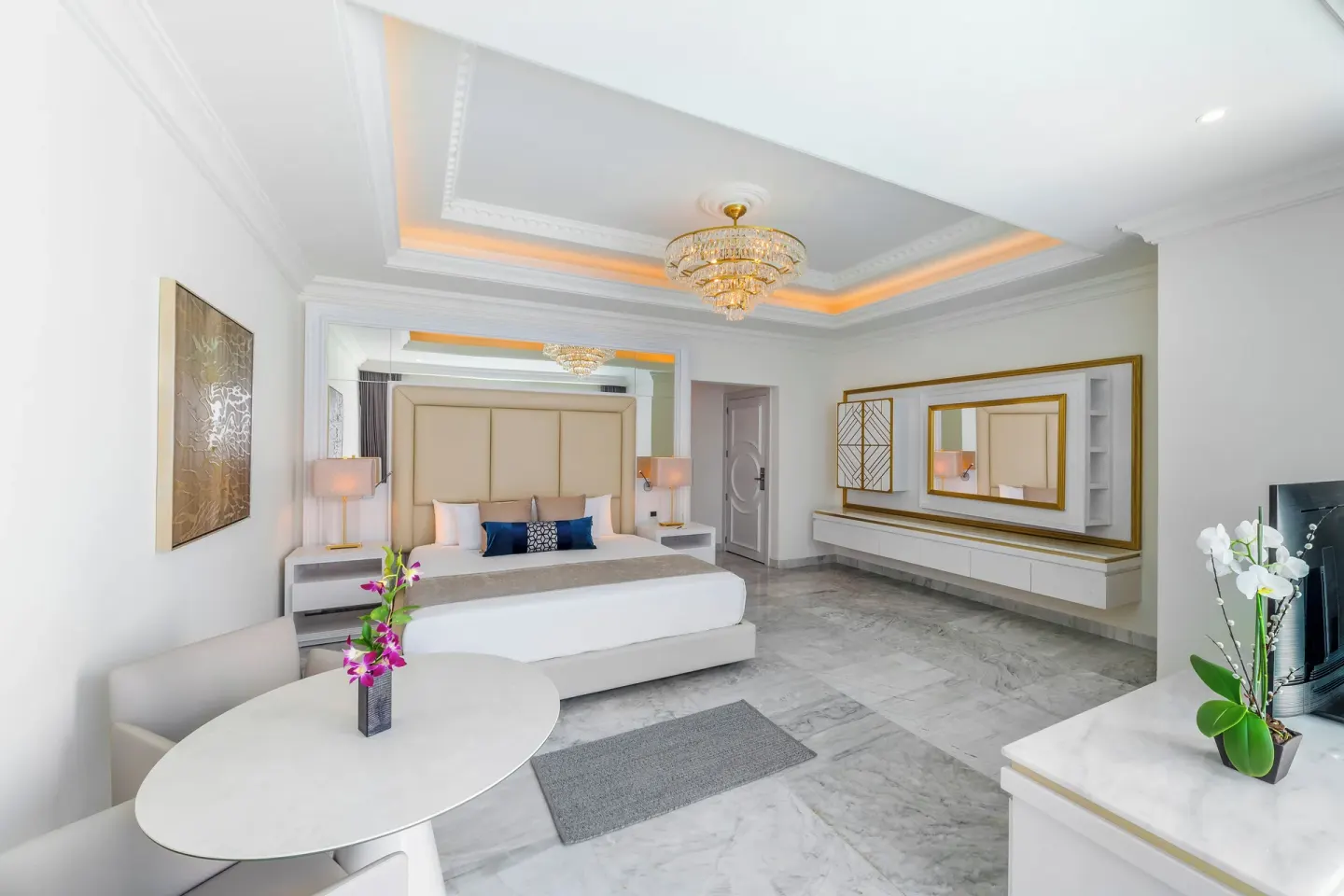 Mansion Jacuzzi Suite with king bed, table, mirror and TV at Desire Pearl Riviera Maya Resort.