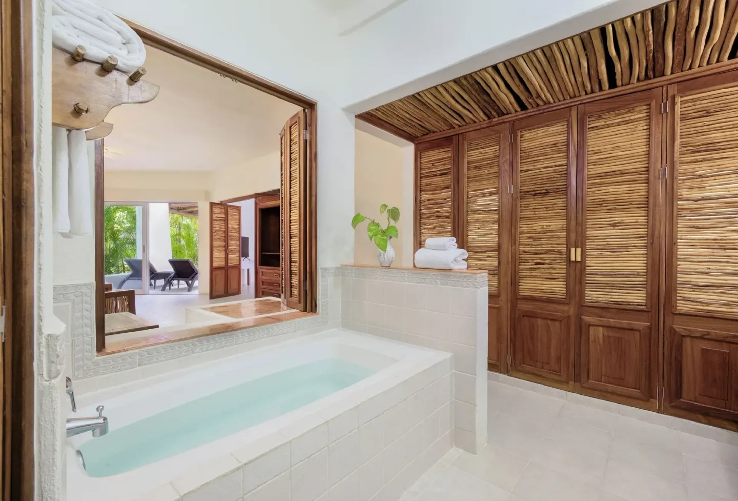Master Suite bathroom with tub and wood shutters at Desire Pearl Riviera Maya Resort.