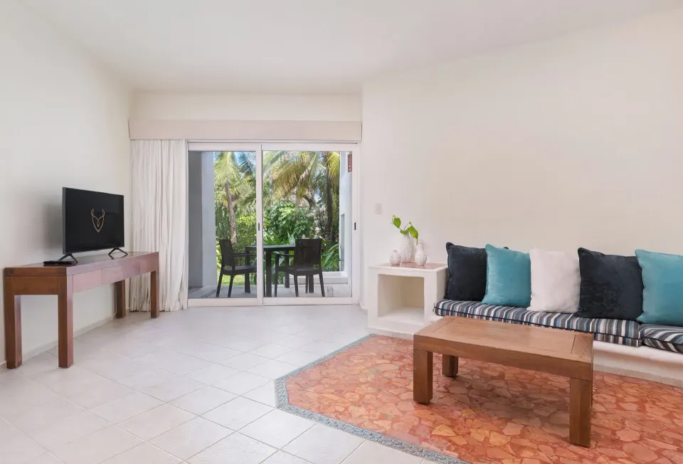 Master Suite sitting area with sofa and terrace doors at Desire Pearl Riviera Maya Resort.