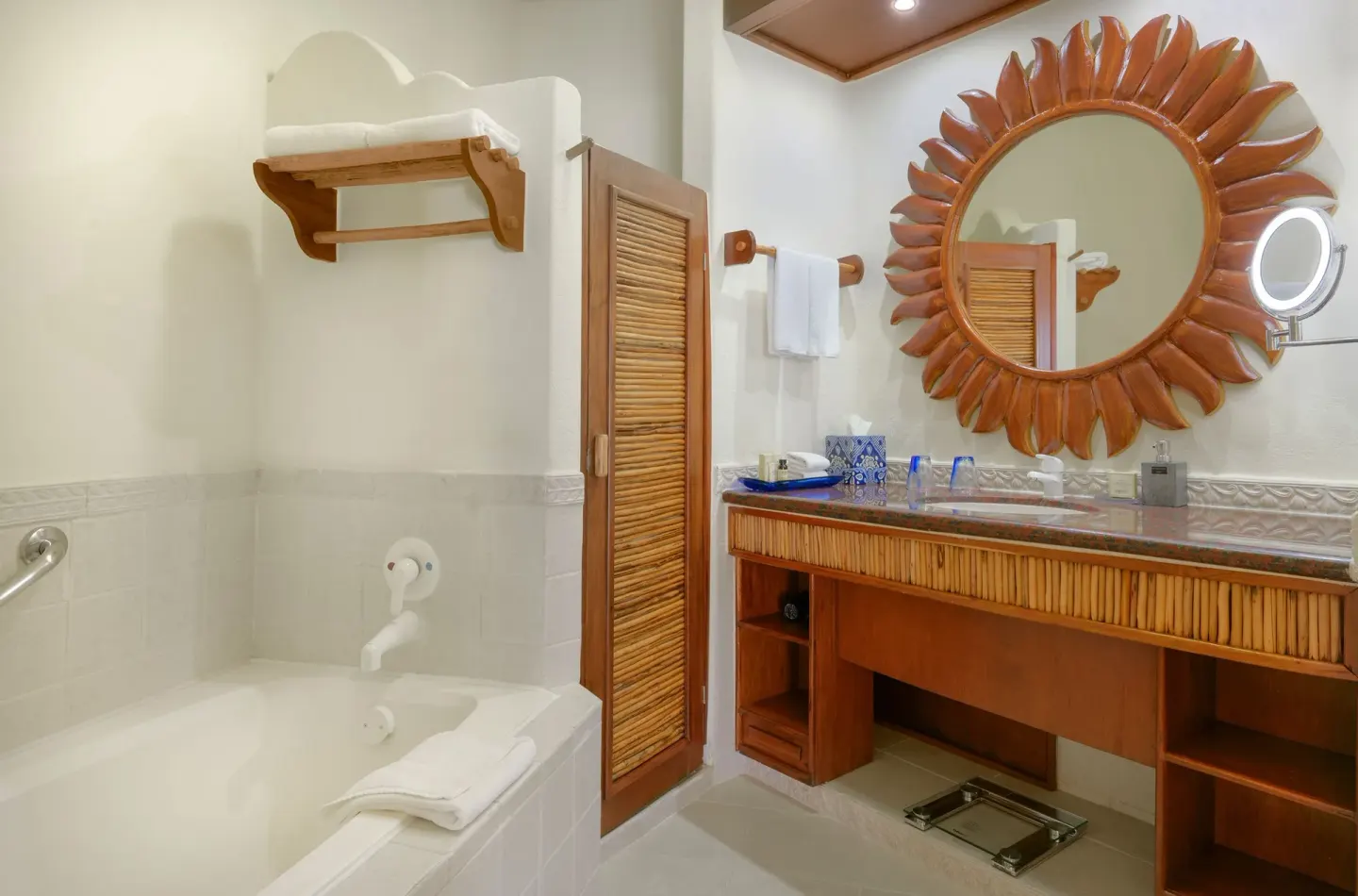 Ocean View bathroom with tub, vanity, and sunburst mirror at Desire Pearl Riviera Maya Resort.