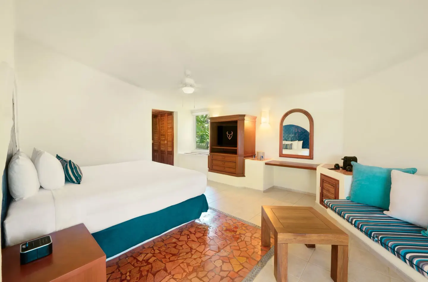 Ocean View room with king bed, seating nook, TV, and vanity at Desire Pearl Riviera Maya Resort.