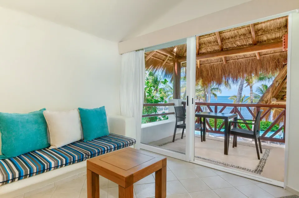 Ocean View room lounge with striped bench and ocean-facing balcony at Desire Pearl Riviera Maya Resort.