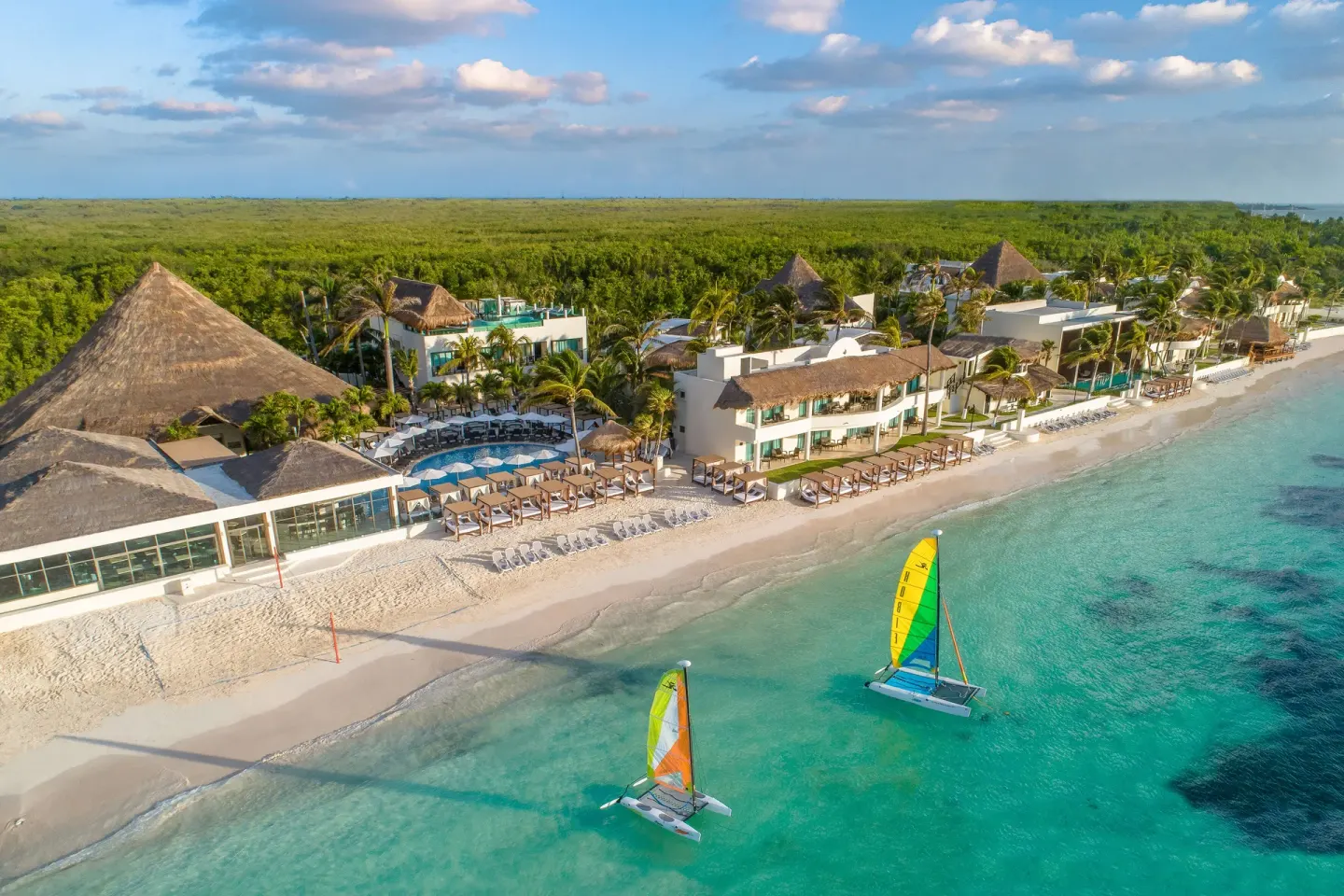 Aerial beachfront view with catamarans at Desire Riviera Maya Resort.