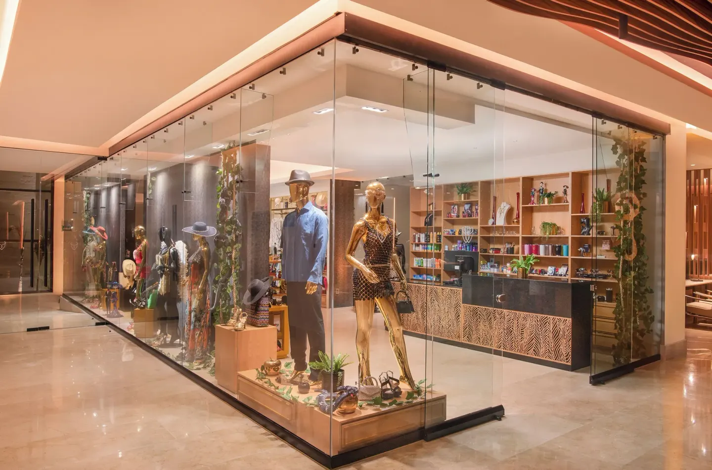 Glass-front boutique display with mannequins inside Desire Riviera Maya Resort.