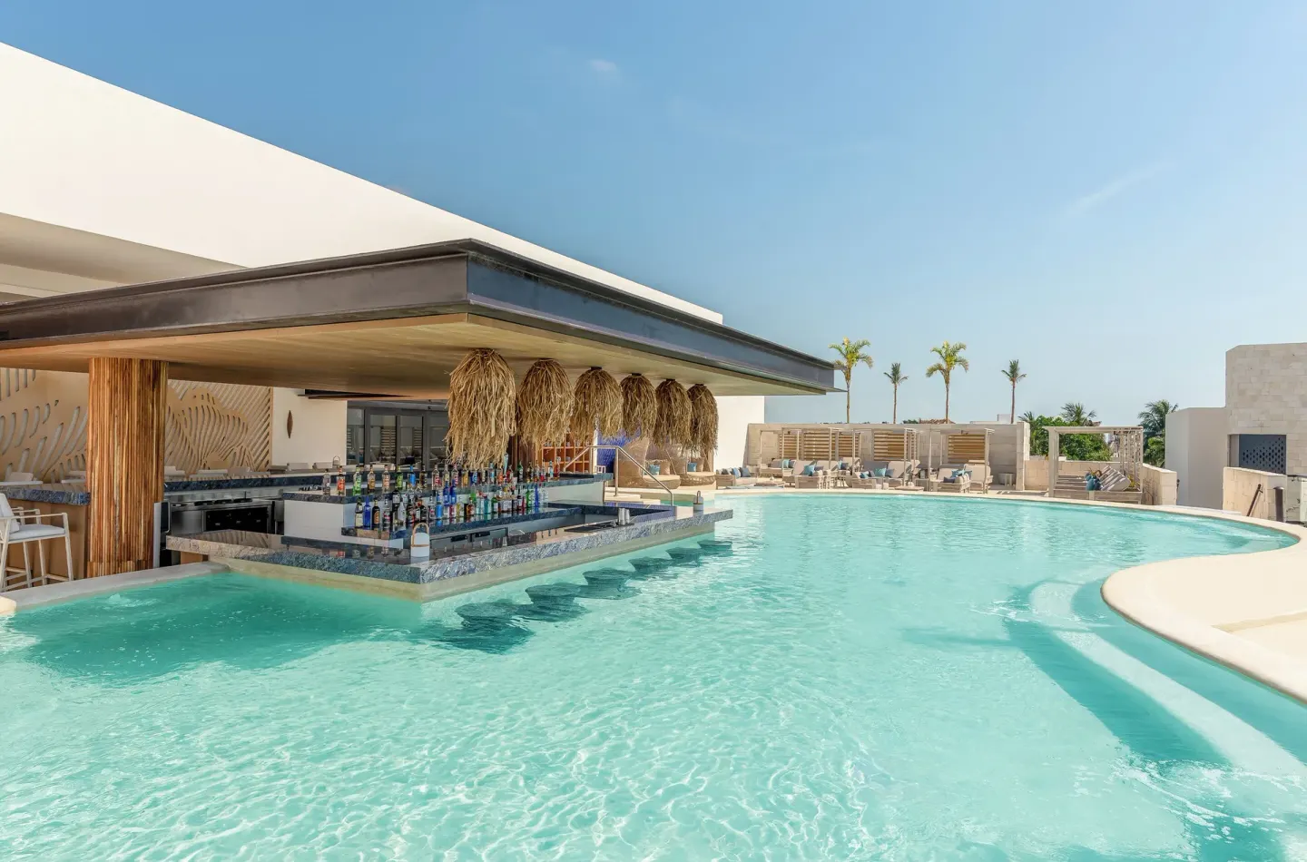 Rooftop pool with swim-up bar at Desire Riviera Maya Resort.
