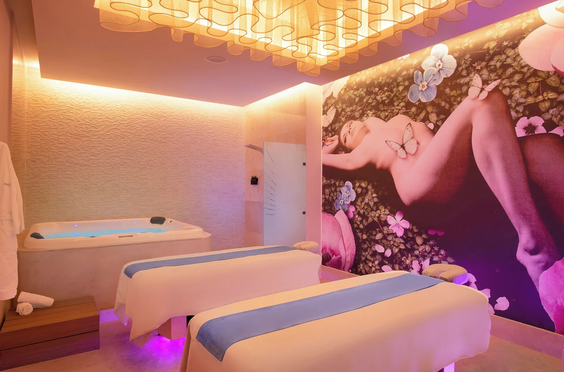 Spa treatment room with massage tables and whirlpool tub at Desire Riviera Maya Resort.