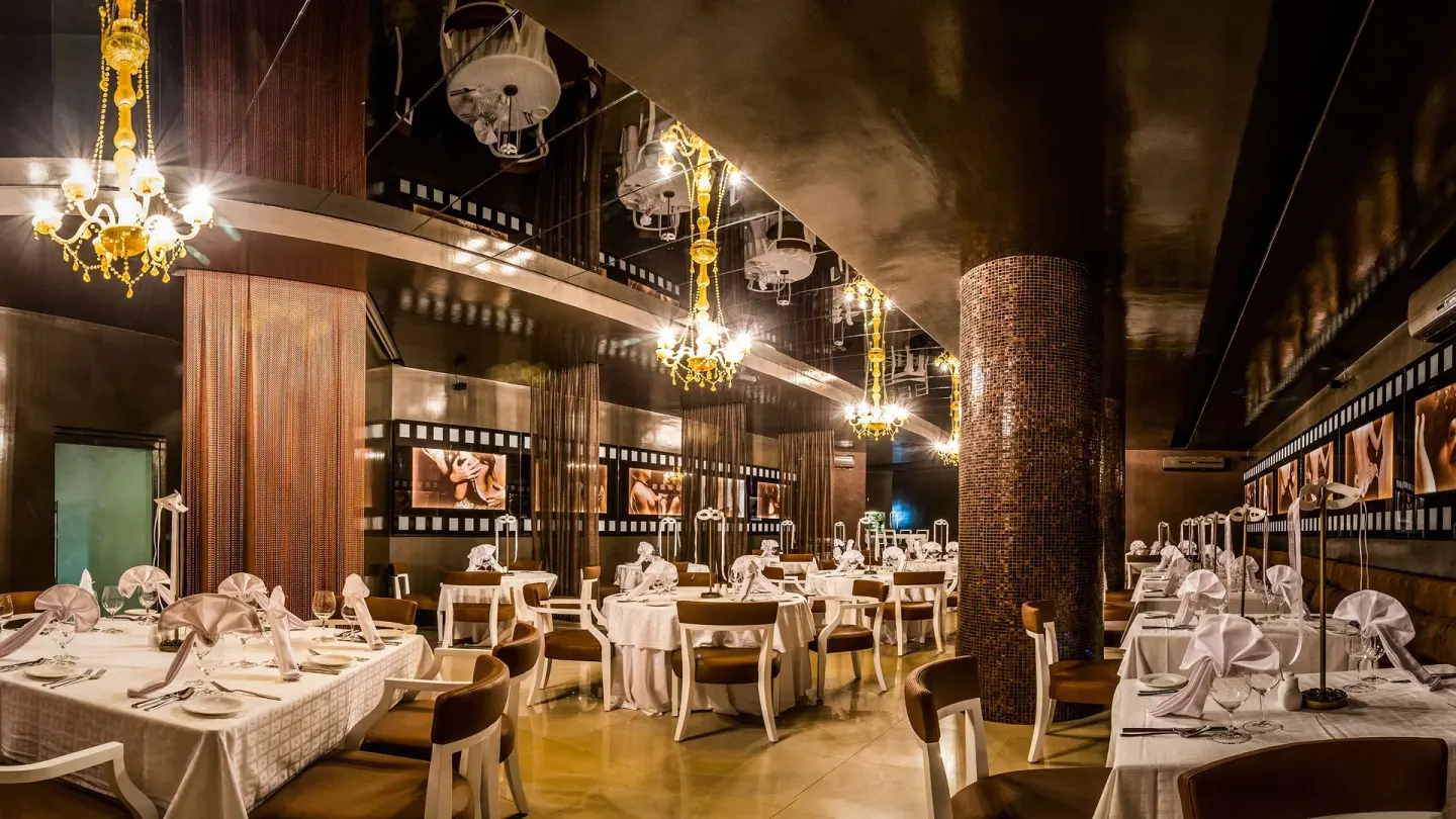 Elegant dark dining room with set tables at Desire Riviera Maya Resort.