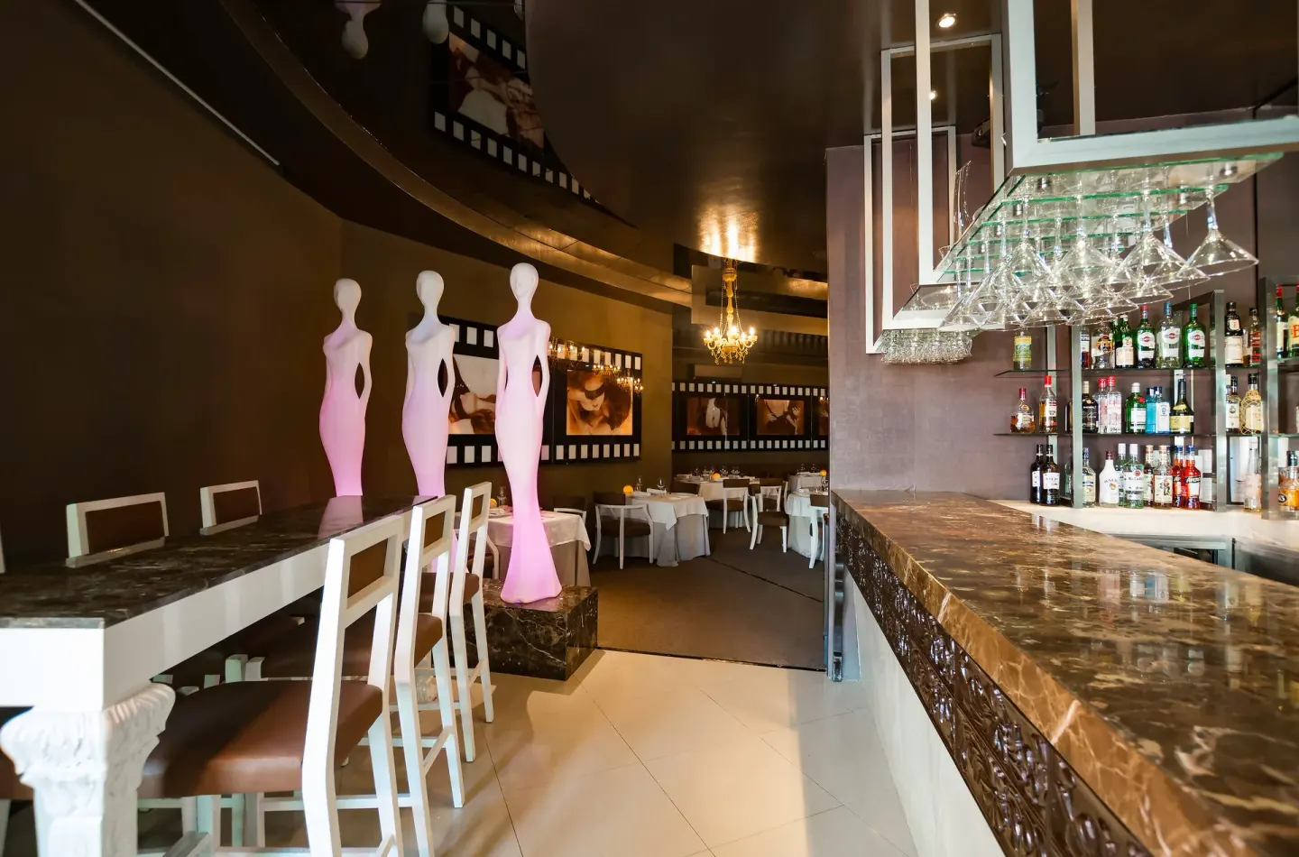 Indoor bar and lounge with sculptural figures at Desire Riviera Maya Resort.