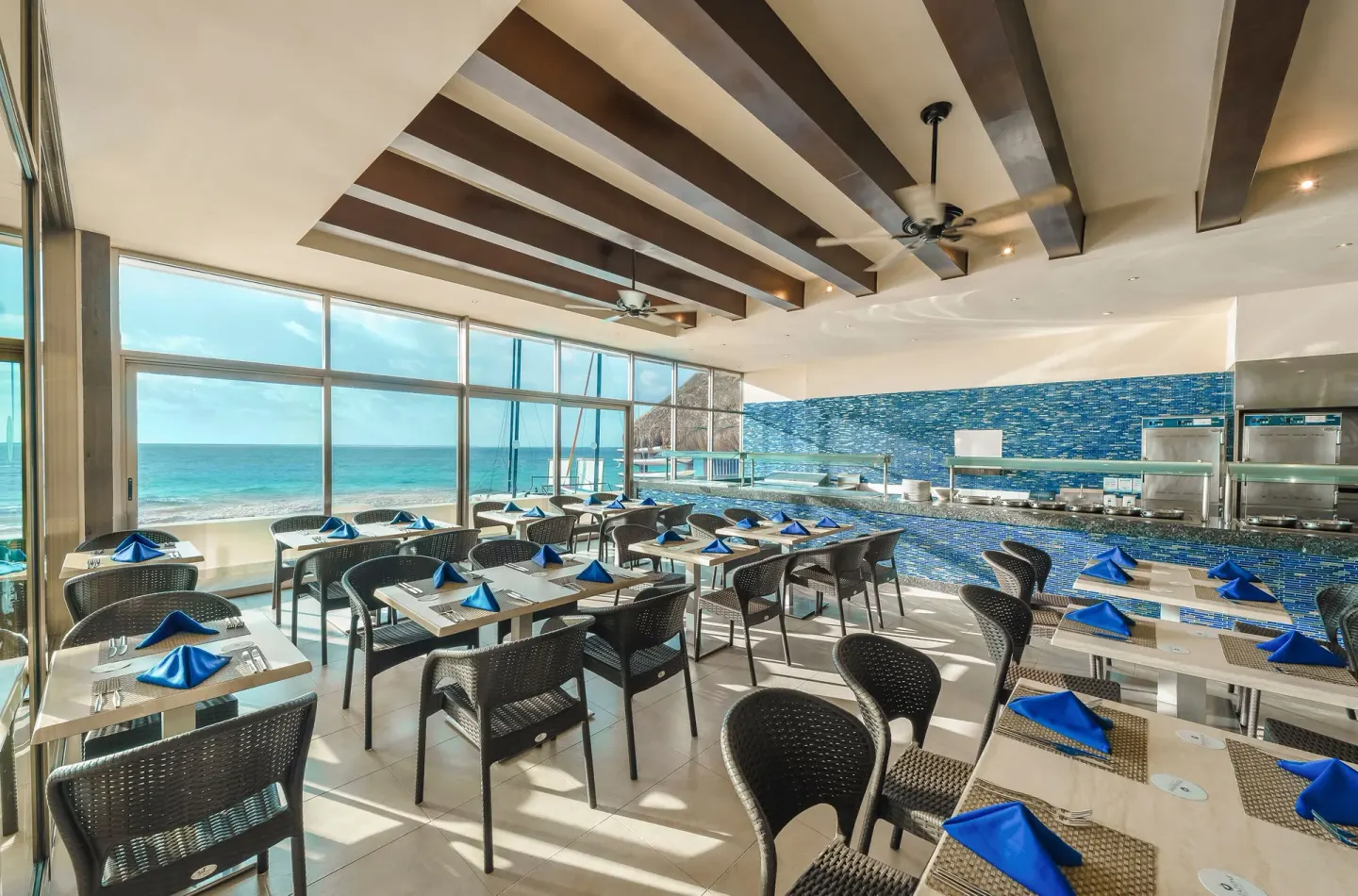 Buffet dining room with ocean-facing windows at Desire Riviera Maya Resort.