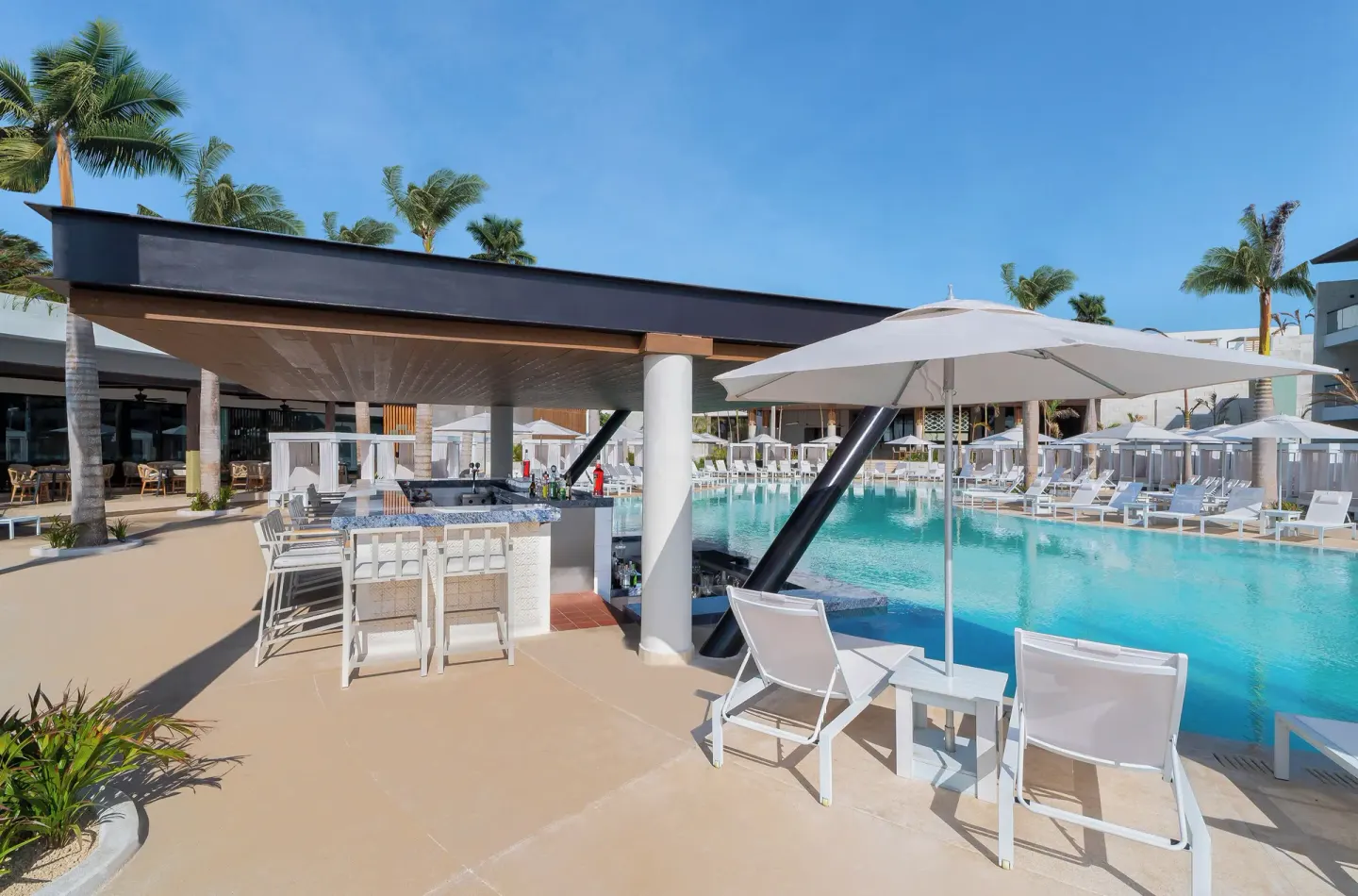 Poolside swim-up bar and loungers beside the pool at Desire Riviera Maya Resort.
