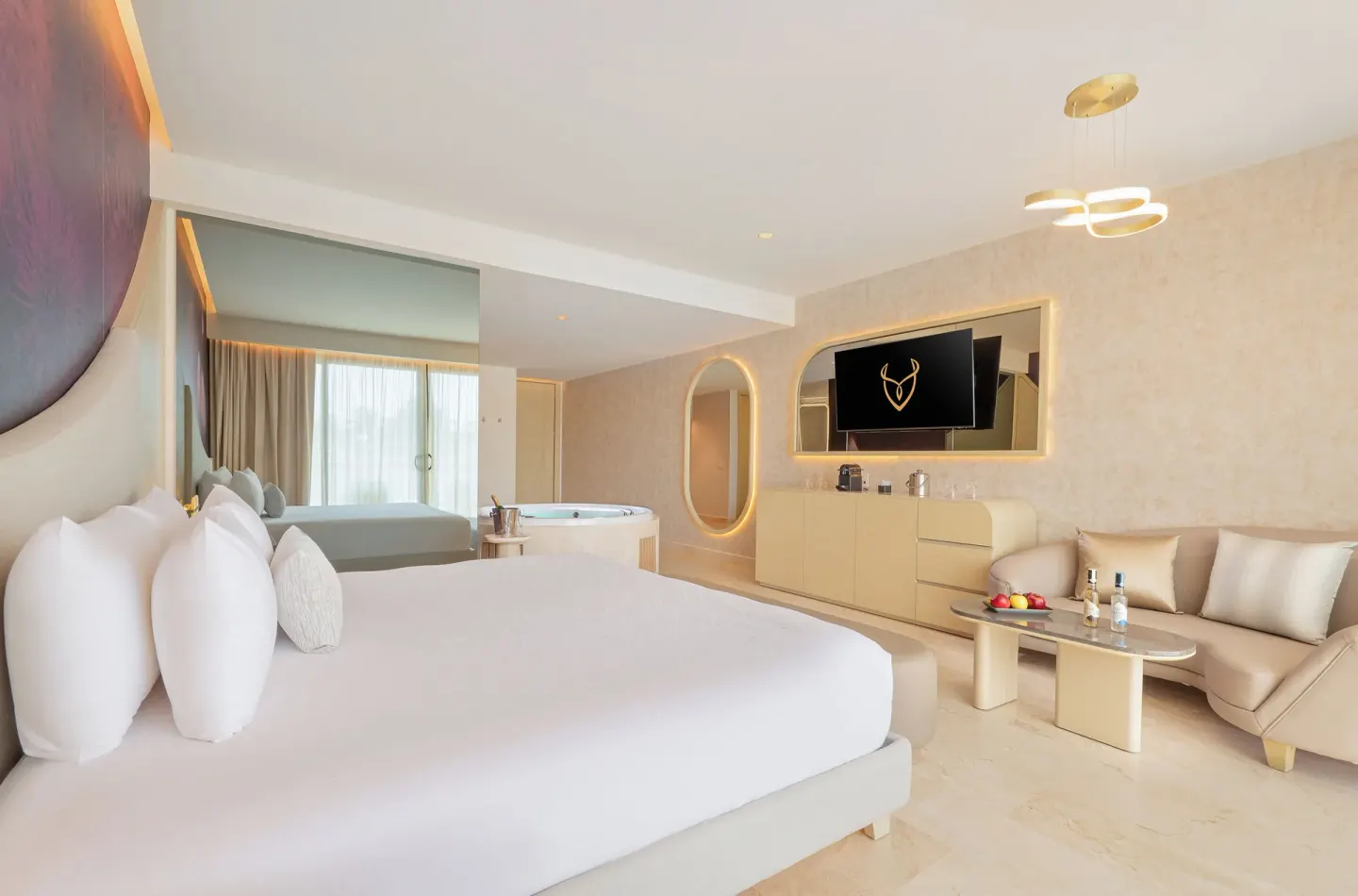 King bed, sofa, and in-room tub in a Beloved Tropical View Jacuzzi Suite at Desire Riviera Maya Resort.