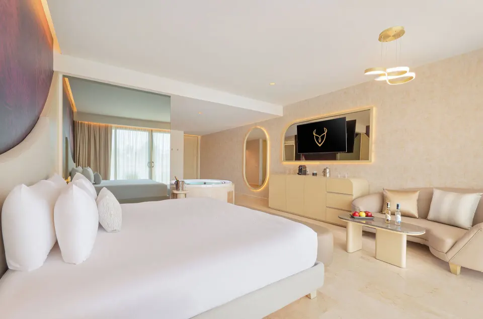 King bed, sofa, and in-room tub in a Beloved Tropical View Jacuzzi Suite at Desire Riviera Maya Resort.