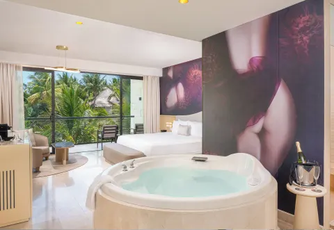 Beloved Tropical-View Jacuzzi Suite with king bed and indoor tub at Desire Riviera Maya Resort.