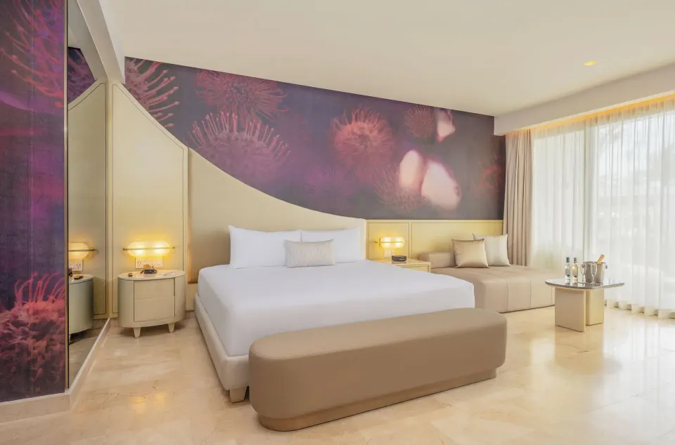 Beloved Tropical-View Swim-up Suite bed, sofa and window at Desire Riviera Maya Resort.