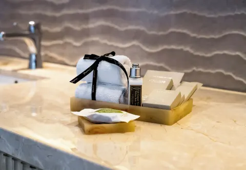 Bathroom vanity amenities and folded towels at Desire Riviera Maya Resort.