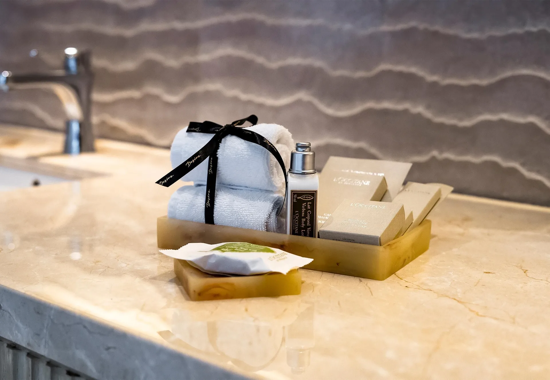 Deluxe Ocean View Room bathroom amenities on a marble vanity at Desire Riviera Maya Resort.