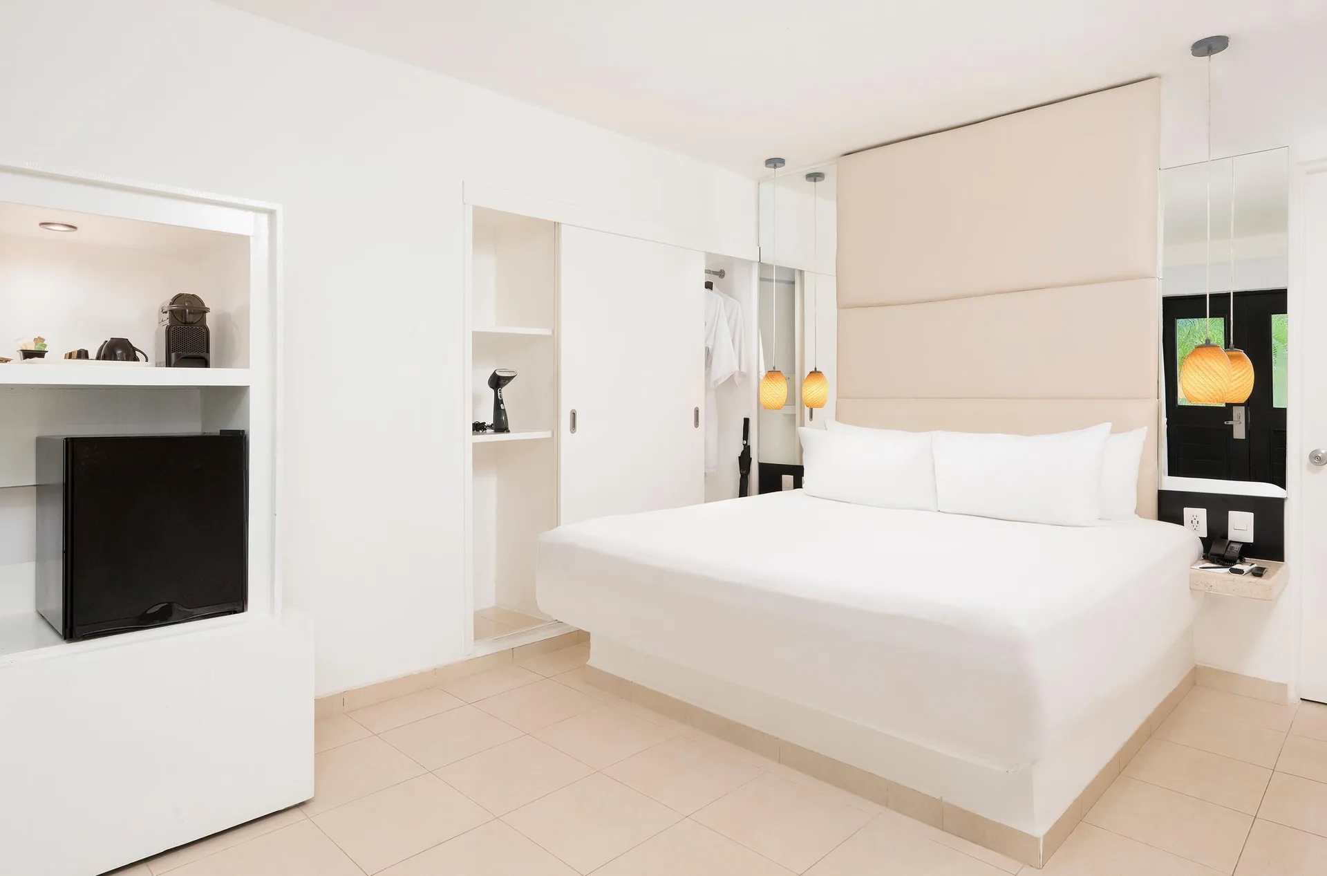 Deluxe Ocean View Room with white king bed and built-in shelves at Desire Riviera Maya Resort.