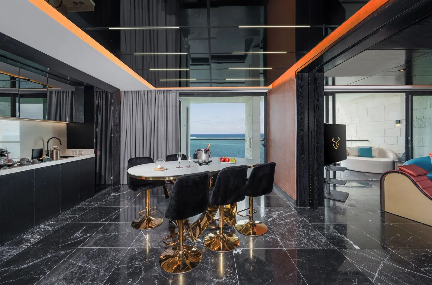 Diamond Ocean View Jacuzzi Suite dining space with balcony view at Desire Riviera Maya Resort.
