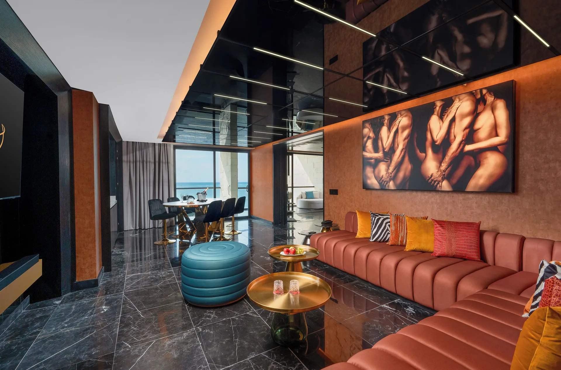 Diamond Ocean-View Jacuzzi Suite lounge with sectional seating and ocean beyond at Desire Riviera Maya Resort.