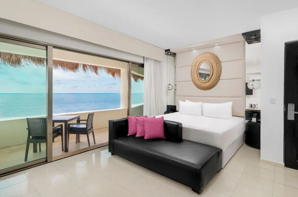 Passion Suite king bed and oceanfront balcony at Desire Riviera Maya Resort.