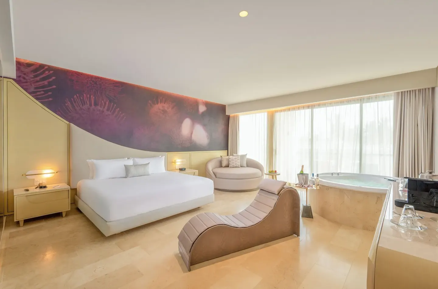 Seductive Pool View Jacuzzi Suite with king bed, lounge chair, and tub at Desire Riviera Maya Resort.