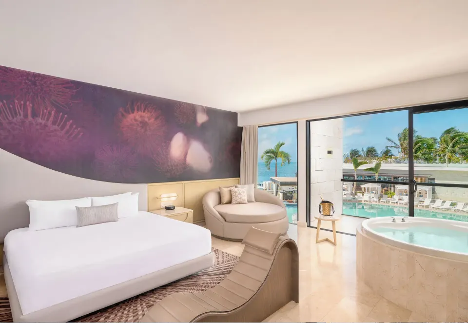 Seductive Pool View Jacuzzi Suite with king bed and whirlpool tub at Desire Riviera Maya Resort.
