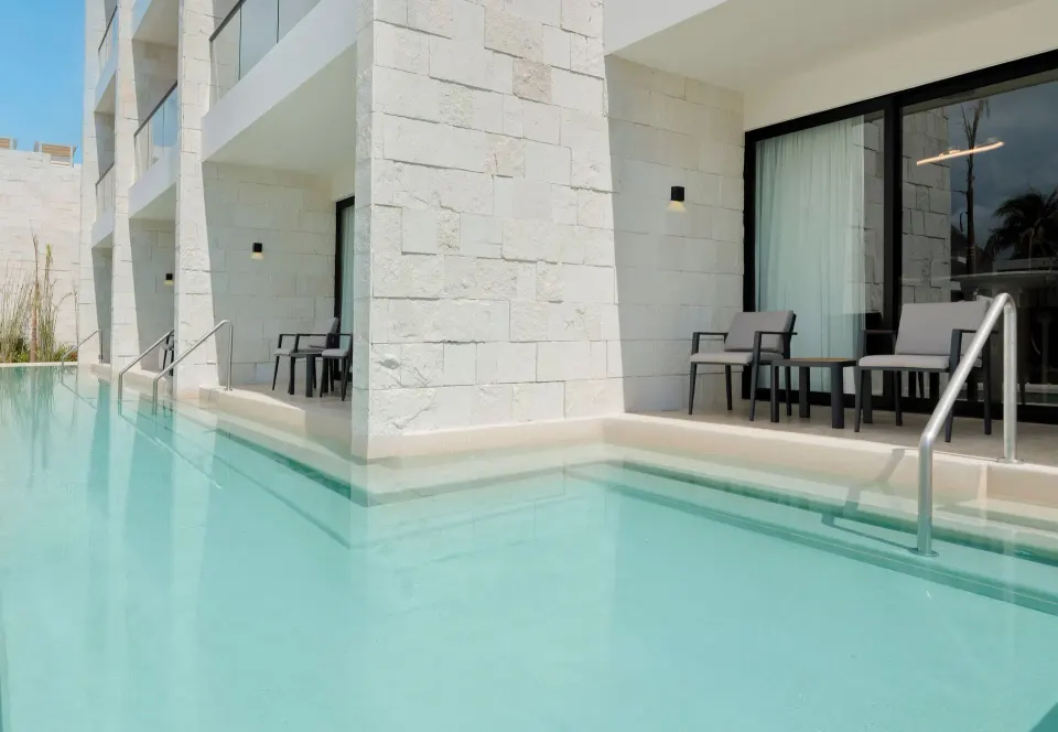 Swim-up suite patios along a pool at Desire Riviera Maya Resort.