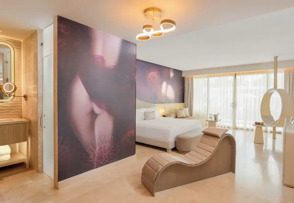 Seductive Pool-View Swim-up Suite king bed and lounge chair at Desire Riviera Maya Resort.