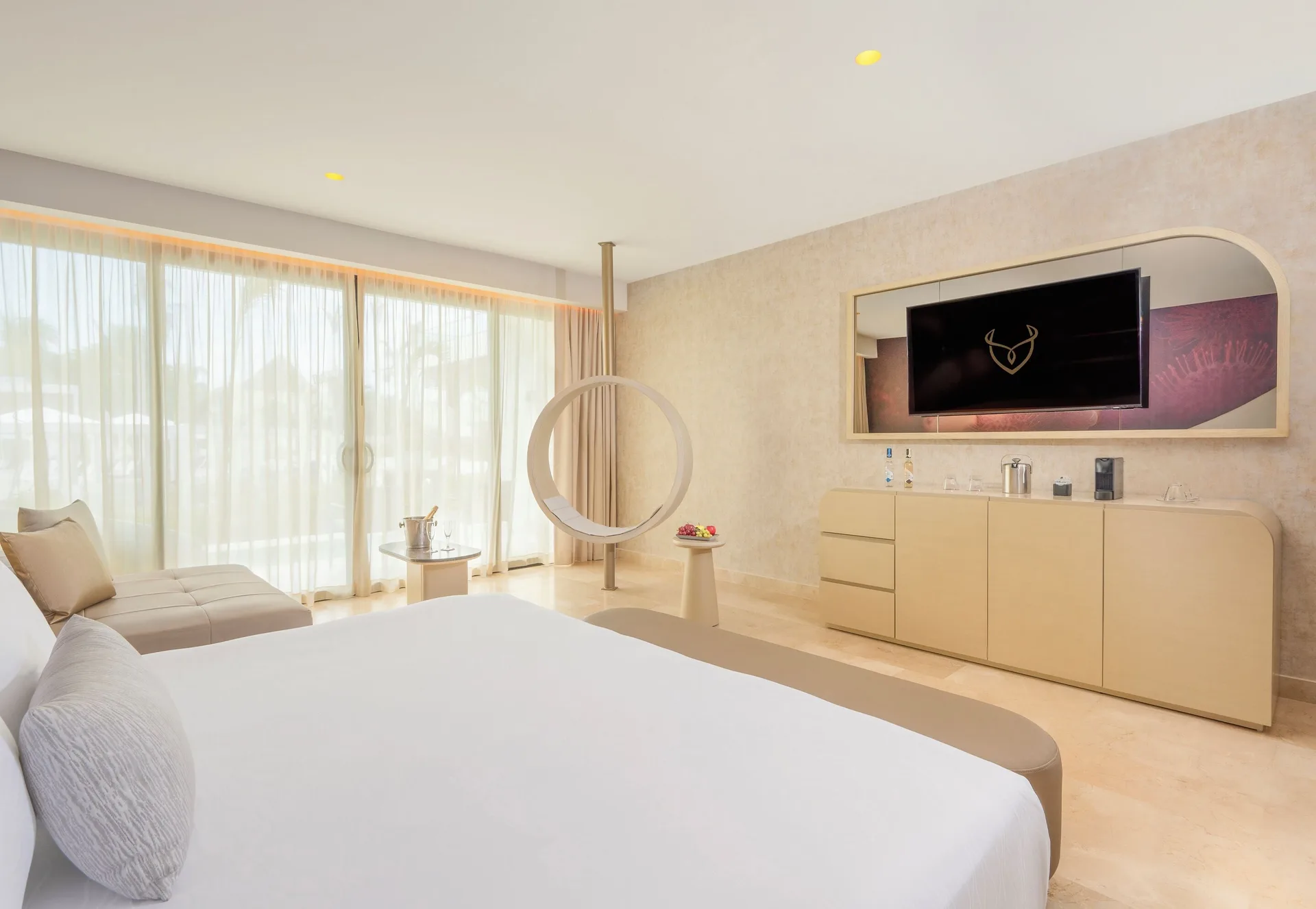 Seductive Pool-View Swim-up Suite bed, ring swing, and media wall at Desire Riviera Maya Resort.
