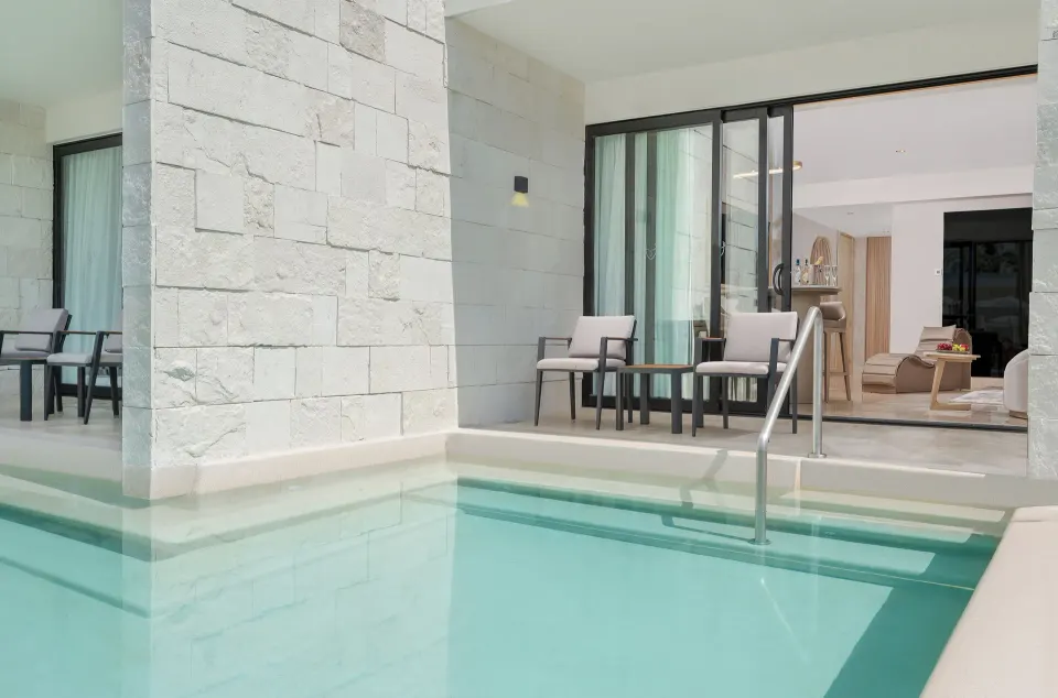 Seductive Pool-View Swim-up Suite patio steps into the pool at Desire Riviera Maya Resort.