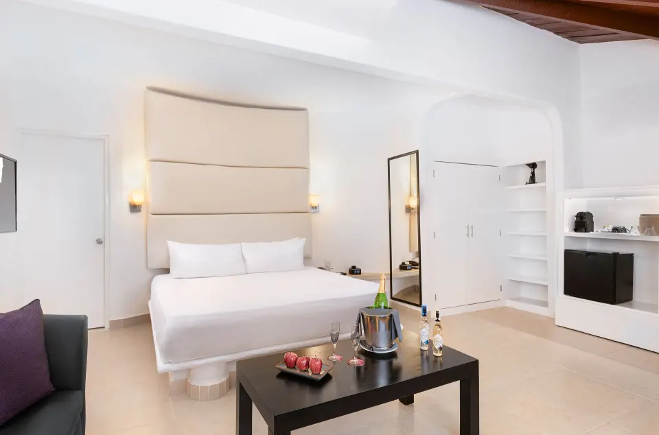 Superior Garden View king bed room with storage and minibar area at Desire Riviera Maya Resort.