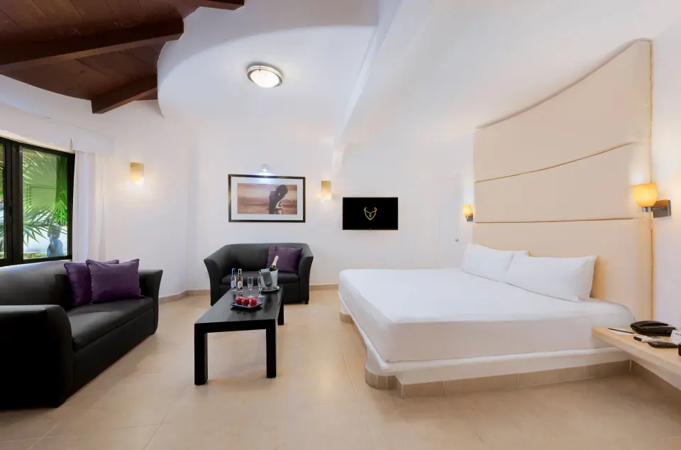 Superior Garden View room with king bed and seating at Desire Riviera Maya Resort.
