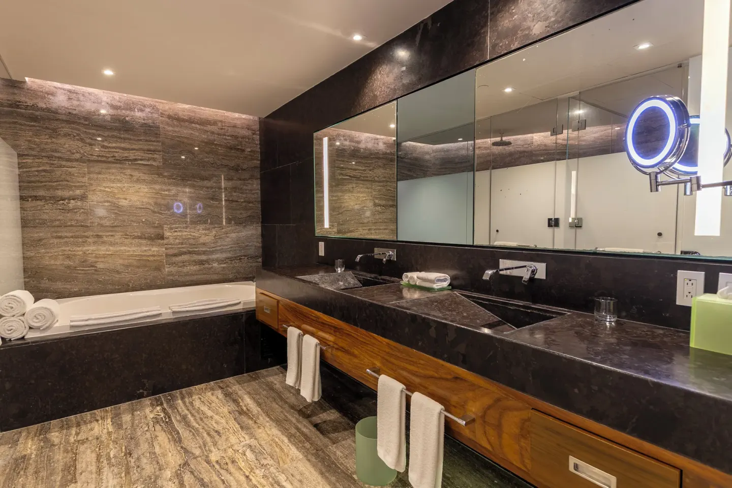 Bathroom with double vanity, bathtub, and large mirrors at Devossion By Live Aqua Playa del Carmen.