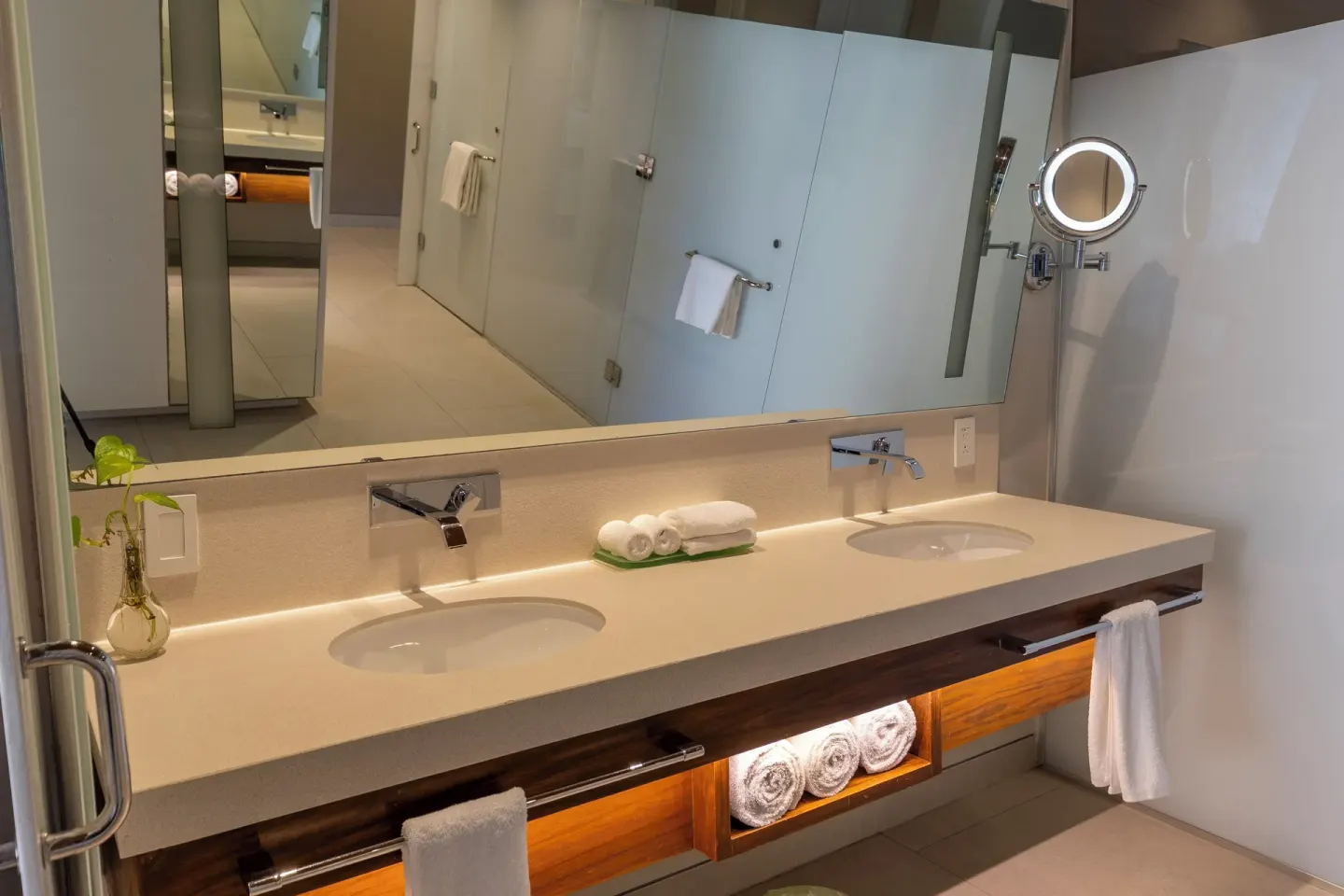 Bright bathroom double vanity with mirror and towels at Devossion By Live Aqua Playa del Carmen.
