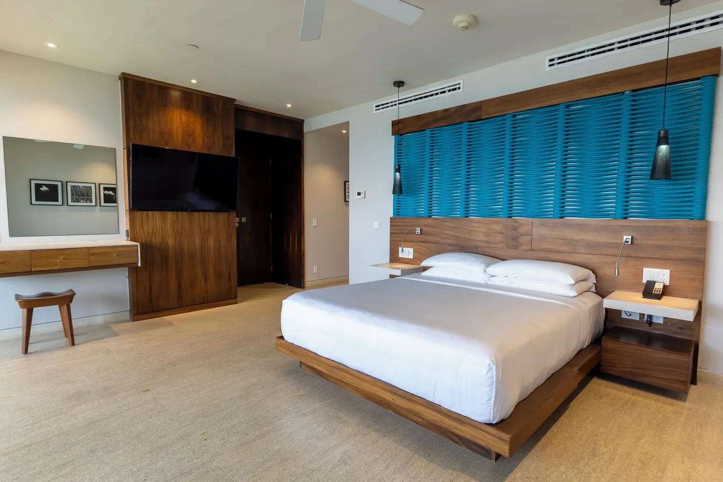 King bed guest room with blue blinds and TV at Devossion By Live Aqua Playa del Carmen.