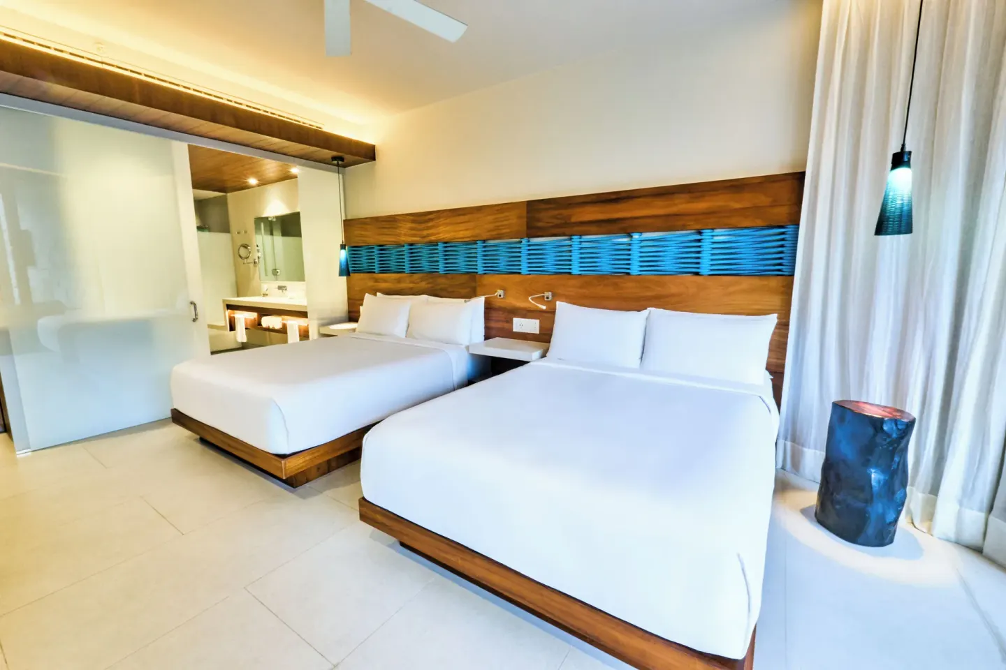 Two-bed guest room with open bathroom at Devossion By Live Aqua Playa del Carmen.