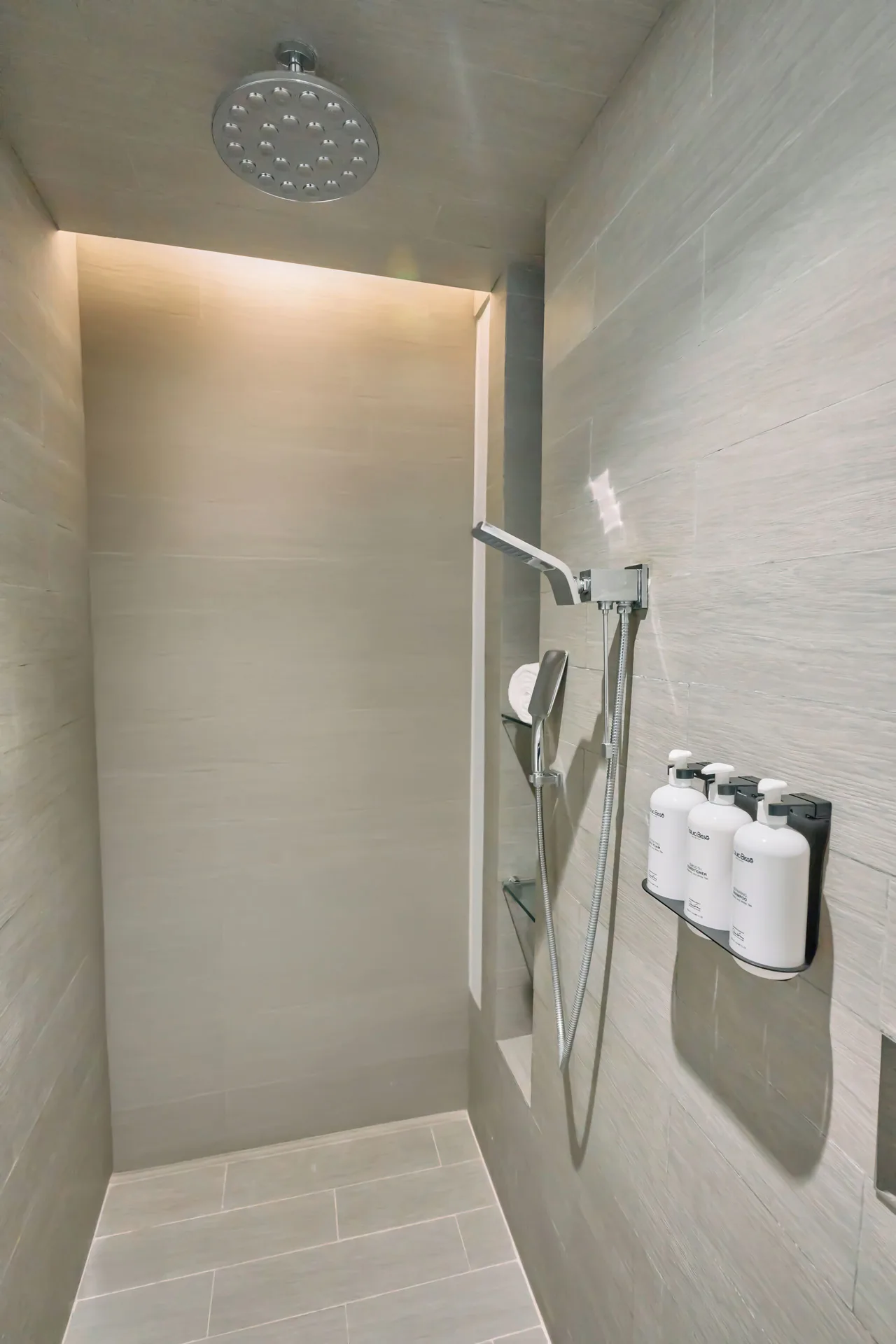 Walk-in shower with rain showerhead and bath amenities at Devossion By Live Aqua Playa del Carmen.