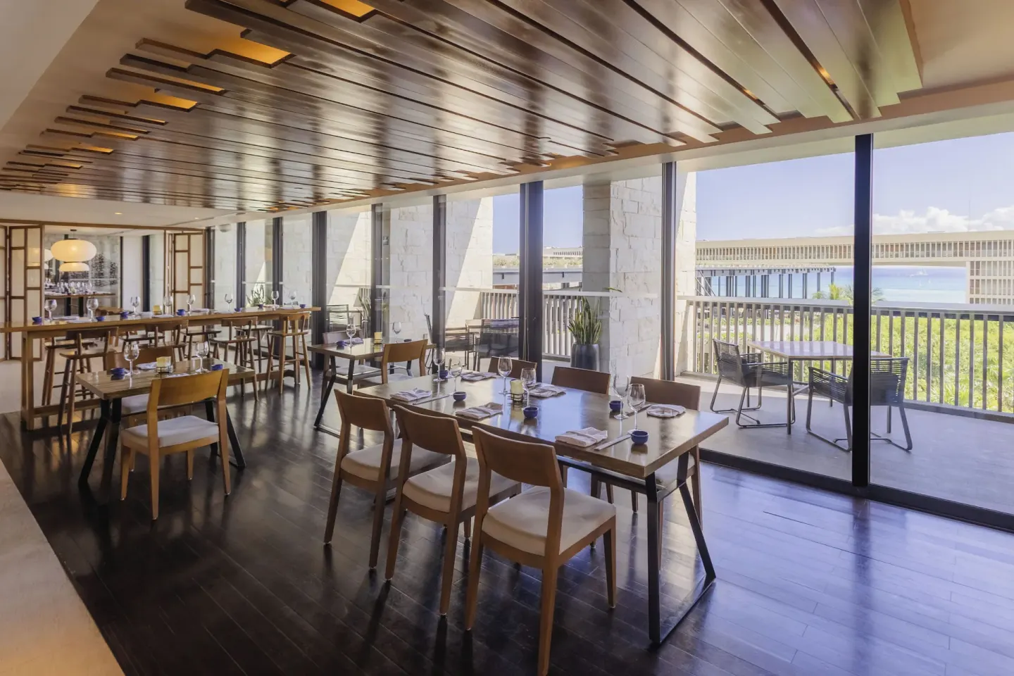 Dining room with set tables and terrace windows at Devossion By Live Aqua Playa del Carmen.