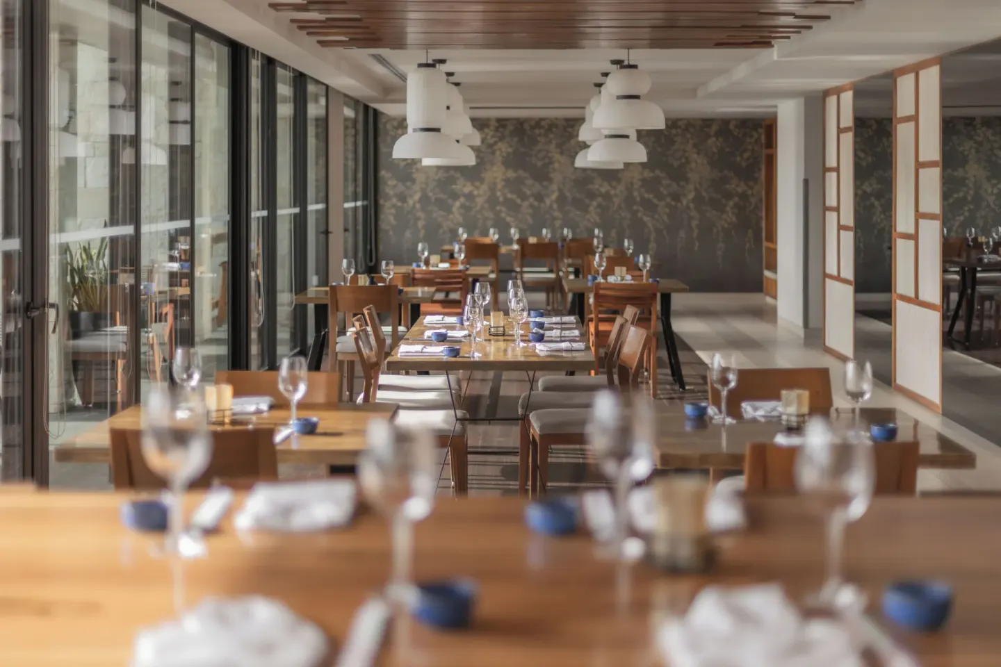 Indoor restaurant tables set with glassware at Devossion By Live Aqua Playa del Carmen.