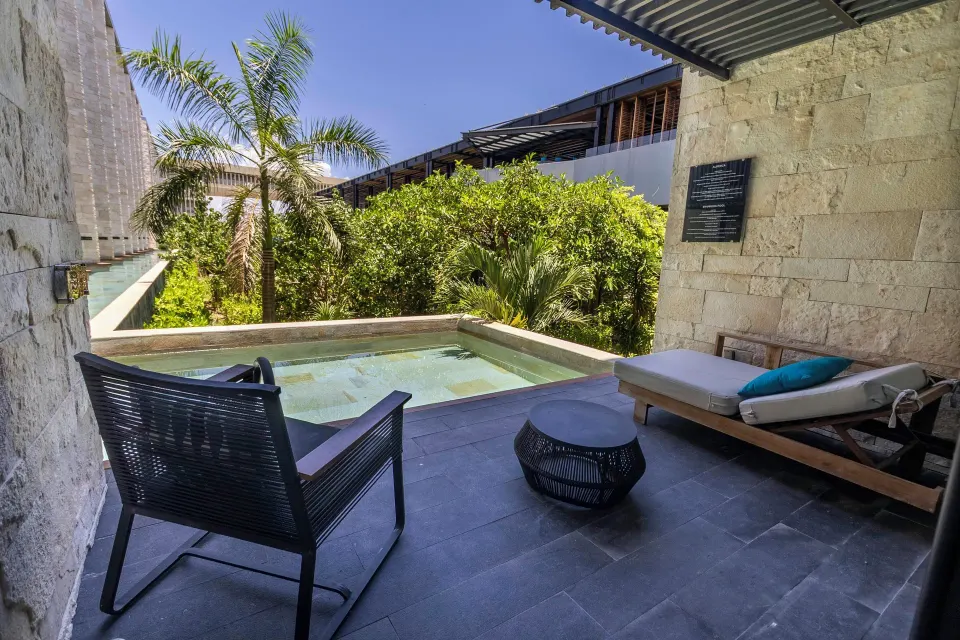 Premium Swim Up room patio with pool and lounge seating at Devossion By Live Aqua Playa del Carmen.