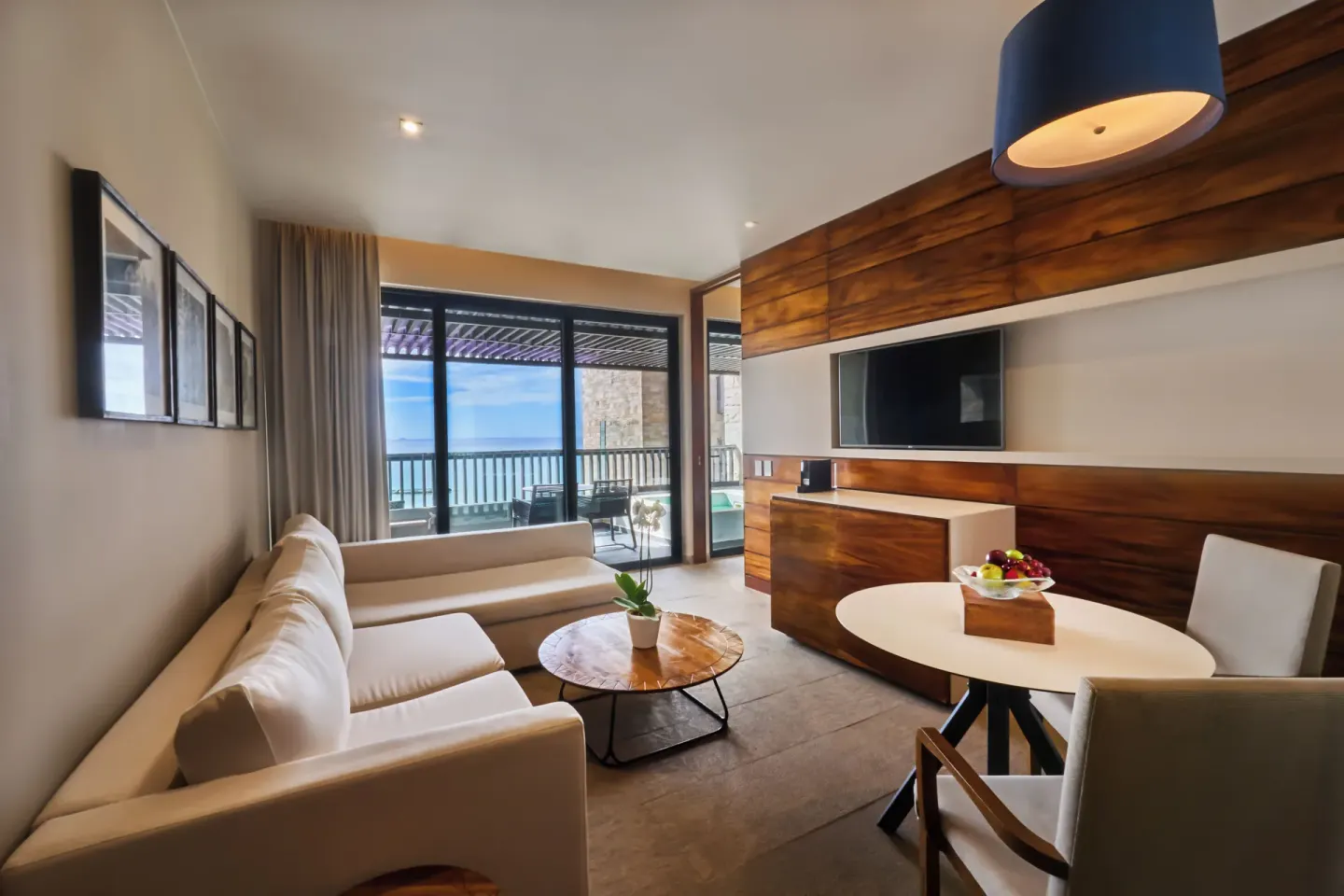 Elixir Plunge Pool suite living area with sofa, dining table and terrace at Devossion By Live Aqua Playa del Carmen.