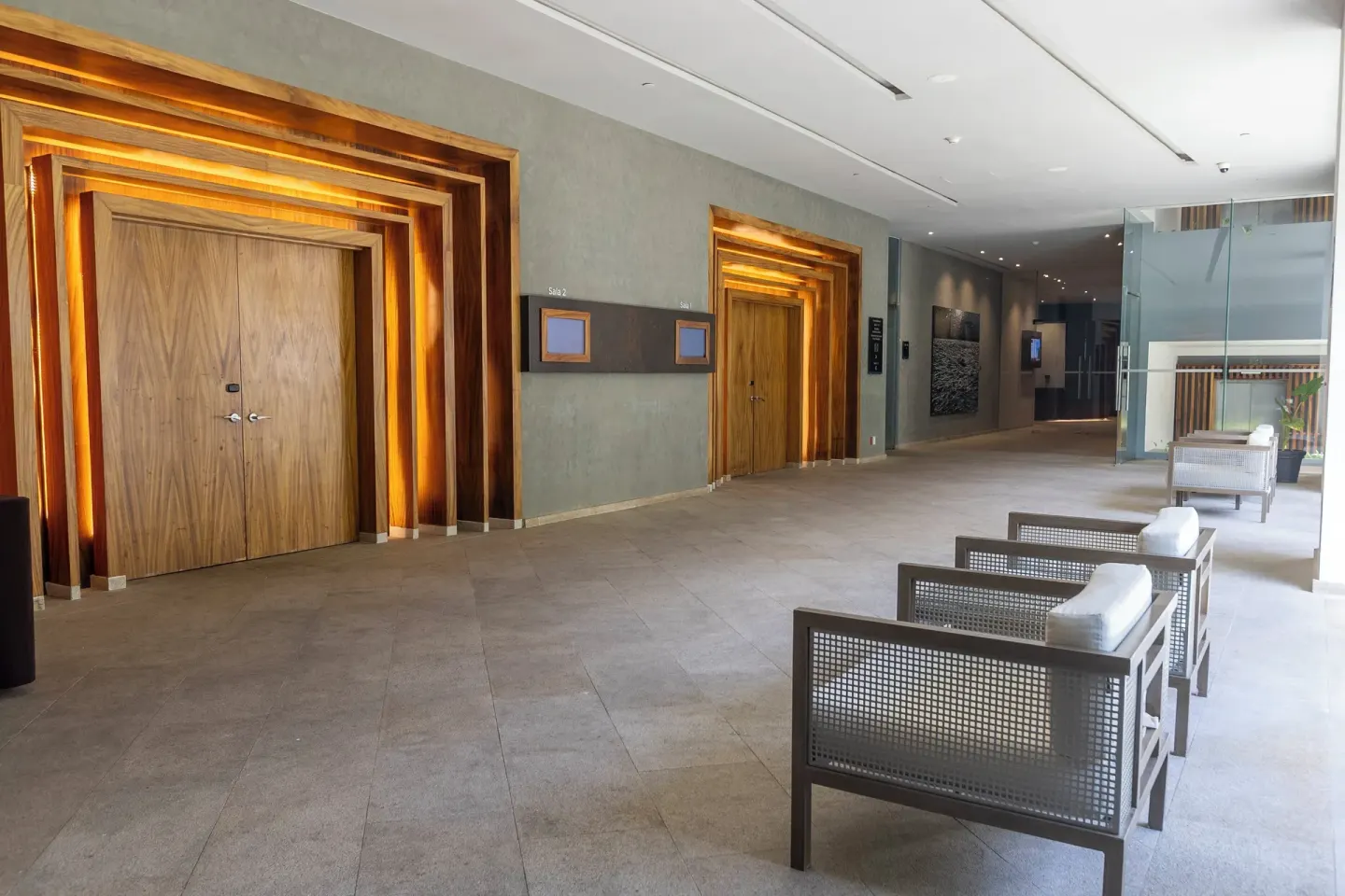 Event corridor with wood doors and lounge chairs at Devossion By Live Aqua Playa del Carmen.